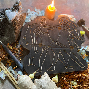 gemini astrology wooden art therapy project surrounded by dried flowers, crystals, and candles