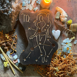 virgo astrology wooden art therapy project surrounded by dried flowers, crystals, and candles