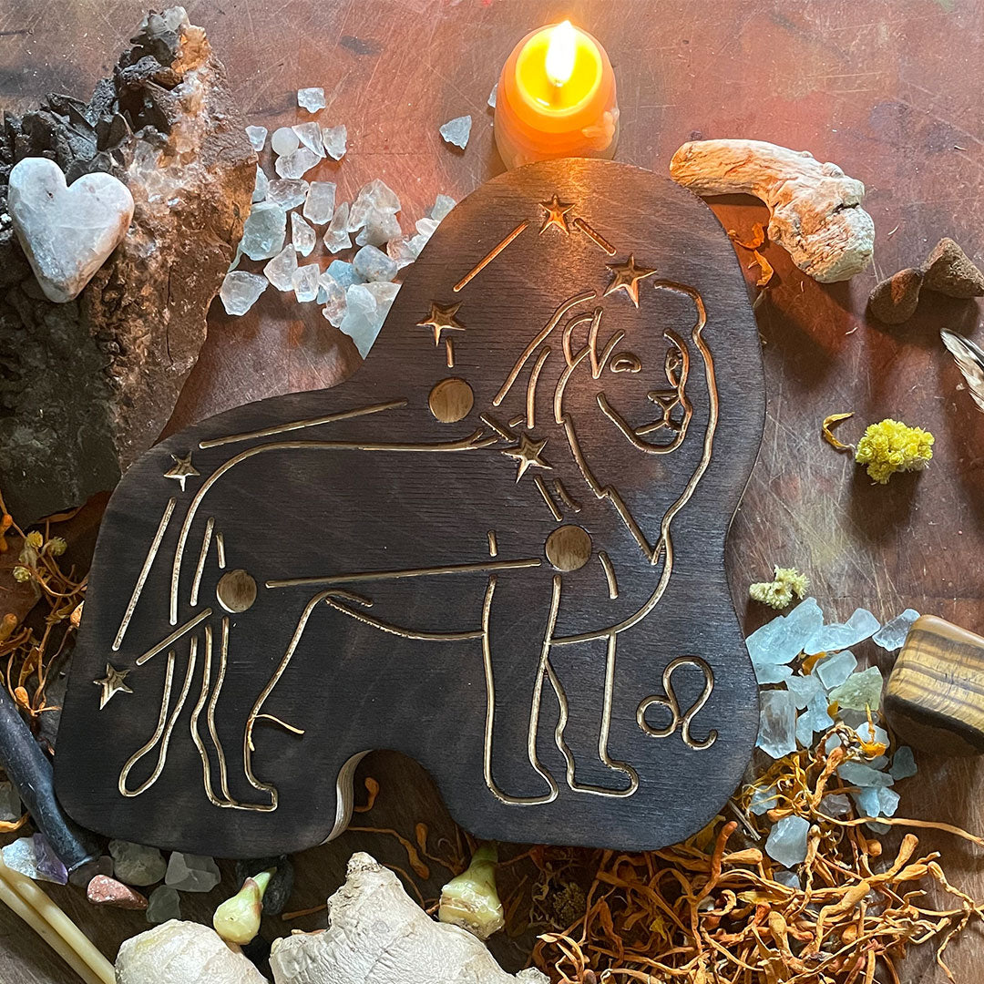 leo astrology wooden art therapy project surrounded by dried flowers, crystals, and candles
