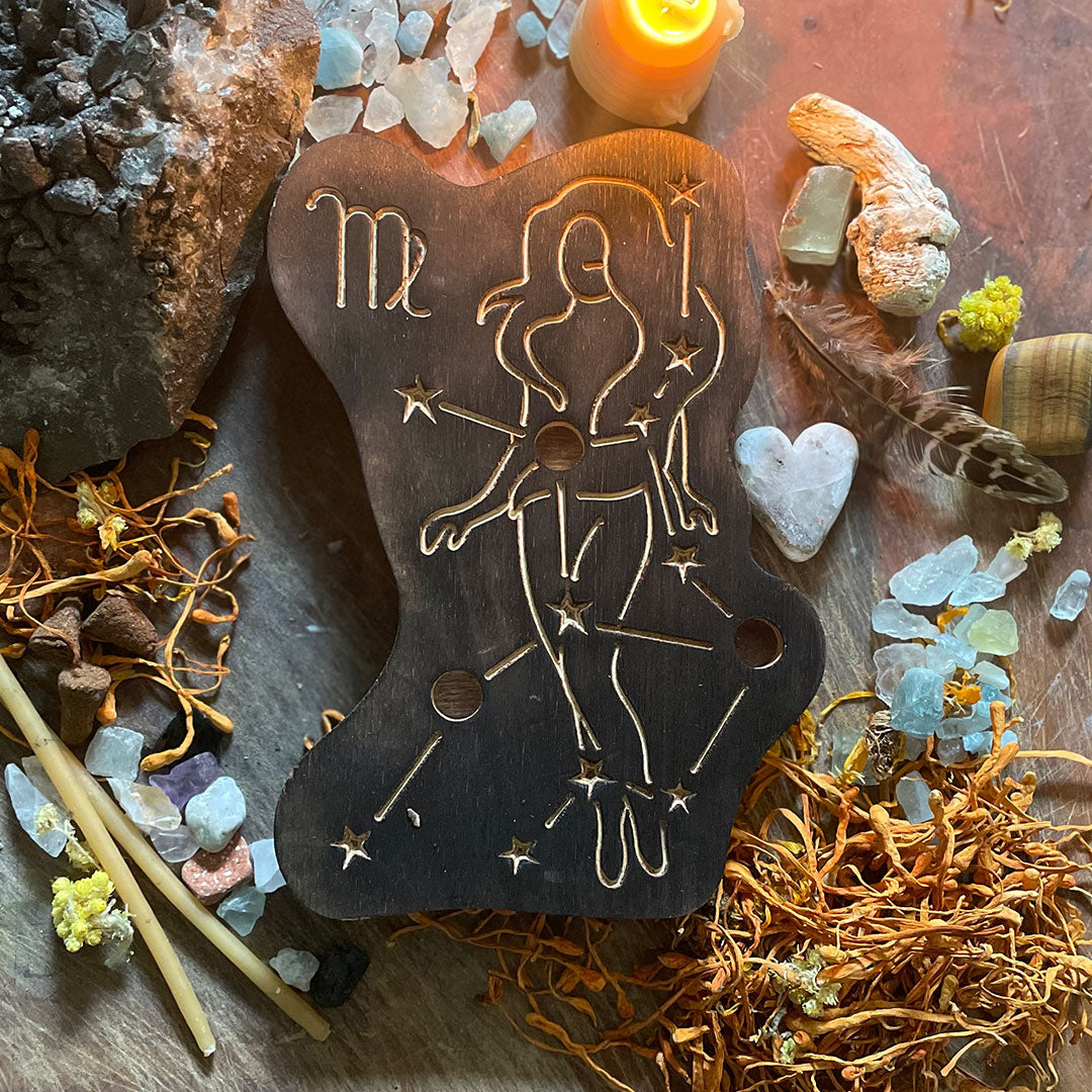 virgo astrology wooden art therapy project surrounded by dried flowers, crystals, and candles